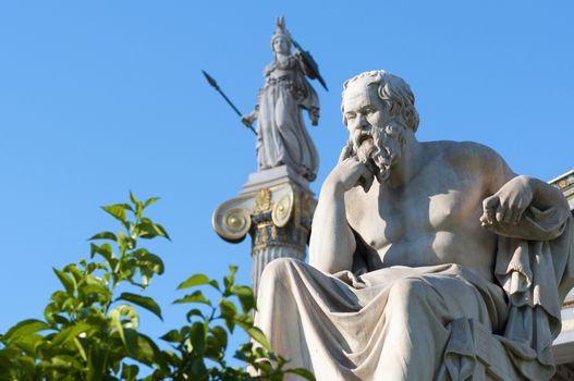 classical statue of Socrates from side with athena statue above and back