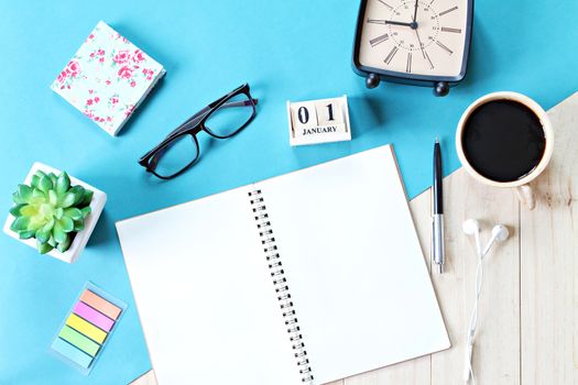 Business, weekend, holiday or new year planning concept : Top view or flat lay of open notebook paper, accessories, cube calendar and coffee cup on wooden background, ready for adding or mock up