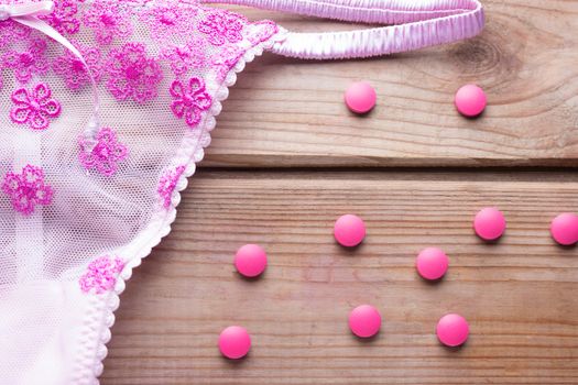 contraceptive pill and pink lingirie. contraception metods concept