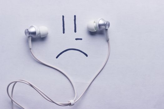 listen to sad music concept. headphones and sad smile