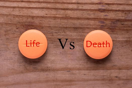 terminal illness treatment concept. pill with words life vs death