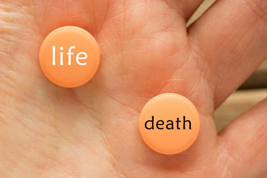terminal illness treatment concept. pill with words life vs death