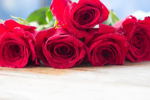 beautiful red color roses on wooden table.copy space