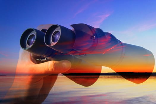 binocular in mans hands on the sea background