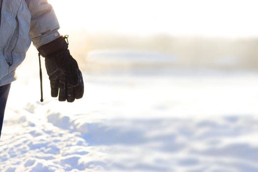 hand in warm gloves on background of snow. copy space