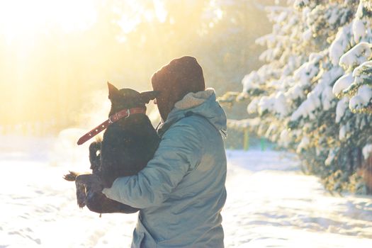 man take dog on his arm, because the dog is ill. winter