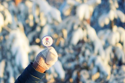 lollipop on stick in hand in mitten. snow background. christmas sweets concept
