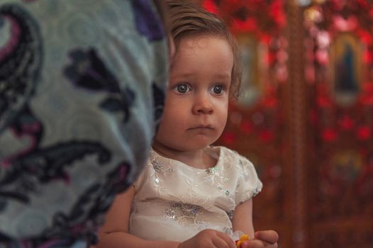 Little girl at moms hand in church on epiphany