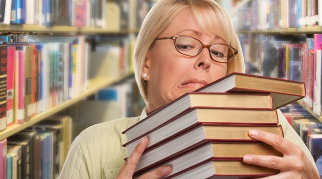 Beautiful Expressive Student or Teacher with Books in Library.