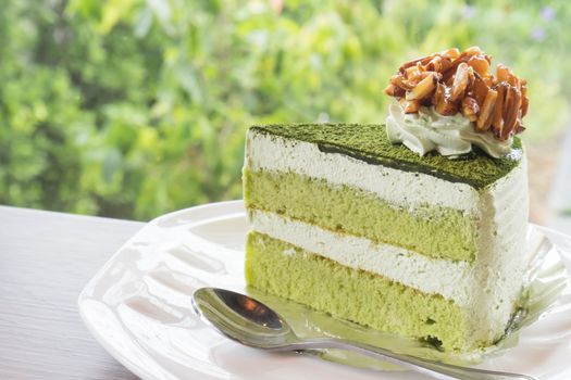 Closeup matcha green tea cake in coffee shop with nature background