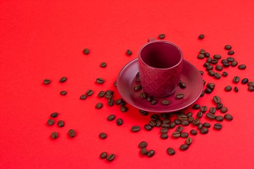 Empty coffee cup and coffee beans on a red background