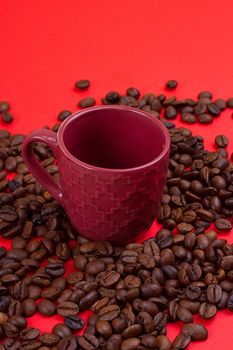 Empty coffee cup and coffee beans on a red background