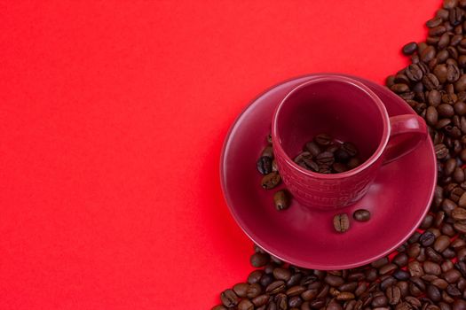 Empty coffee cup and coffee beans on a red background