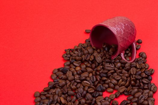 Empty coffee cup and coffee beans on a red background