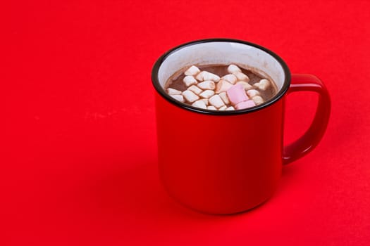 Hot chocolate with marshmallows on the red background