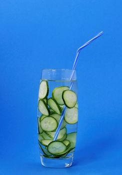  Refreshing and healthy drink of a cucumber in a glass on a blue background