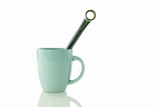 time for a coffee break during work with blue coffe cup and metal boxwrench or spanner isolated on white