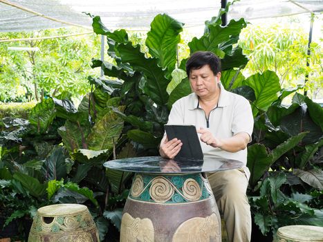 Man finishing work on his tablet and relaxing in the garden.