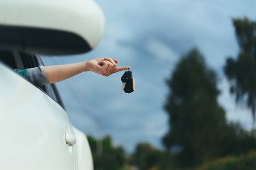 Closeup of car keys hanging on female finger