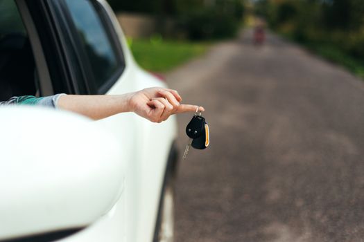 Closeup of car keys hanging on female finger