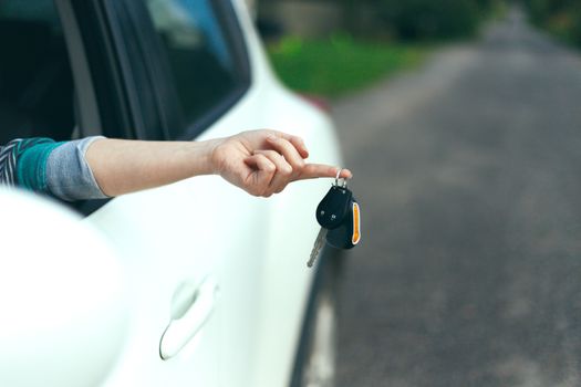 Closeup of car keys hanging on female finger