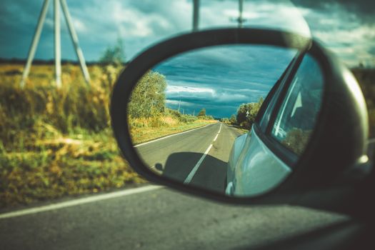 Rearview Mirror View on the Hightway and Blue Sky , Clouds and Sun