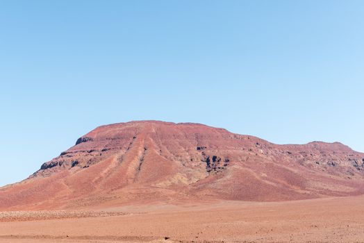 The red, rocky Namib desert landscape near Springbokwasser in the Kunene Region of Namibia