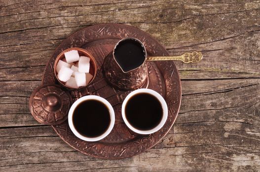 Coffee in copper coasters with accessories for coffee-drinking on old wooden background