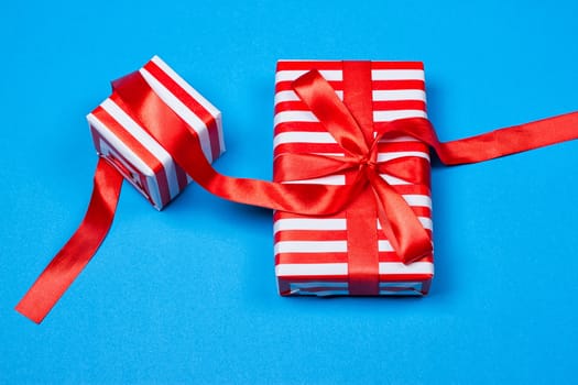 Several neatly laid out gifts in red packing on a blue background. Christmas presents