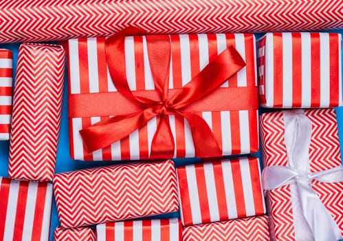 Top view of red and white gifts on the blue background