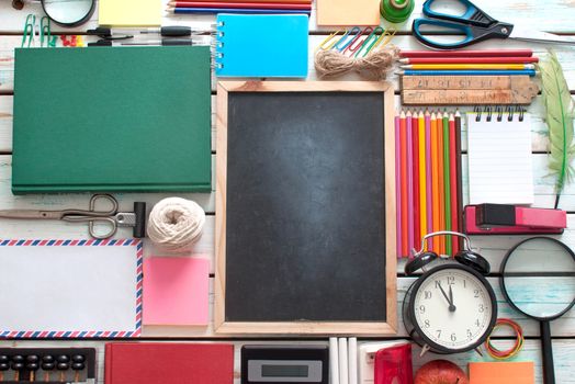 Aerial view of stationery objects with blackboard in the centre