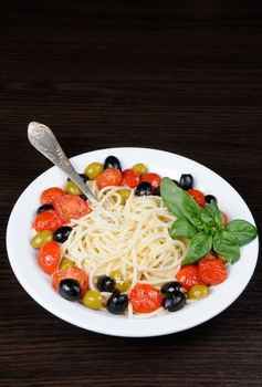 Spaghetti with olives, cherry tomatoes, sprinkled   Parmesan and basil