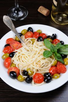 Spaghetti with olives, cherry tomatoes, sprinkled   Parmesan and basil