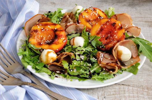 Salad with dried ham, grilled nectarine, mozzarella and arugula