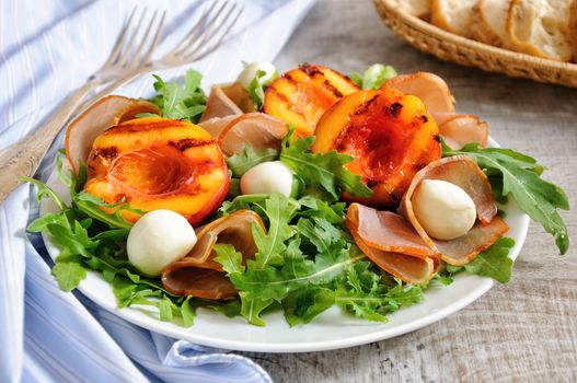 Salad with dried ham, grilled nectarine, mozzarella and arugula