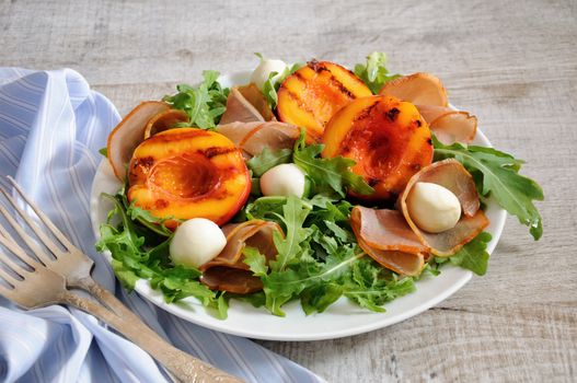 Salad with dried ham, grilled nectarine, mozzarella and arugula
