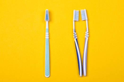 three Toothbrushes on the yellow background. Top view