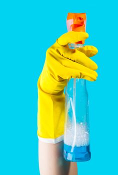 Detergent for cleaning in a female hand on blue background