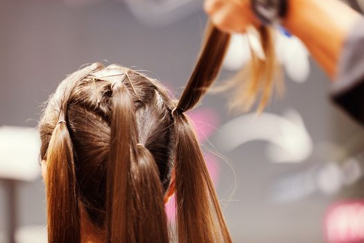 making coiffure with help of hair straightener, note shallow depth of field