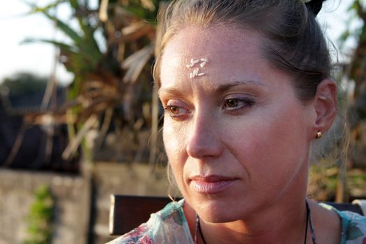 Portrait of a woman with rice on her forehead. Rice on the forehead after the end of prayer is a symbol of longevity, prosperity and closeness to God