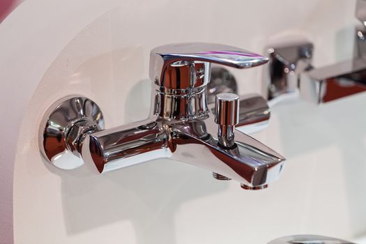 Modern faucet for water on the sink or on the wall, note shallow depth of field