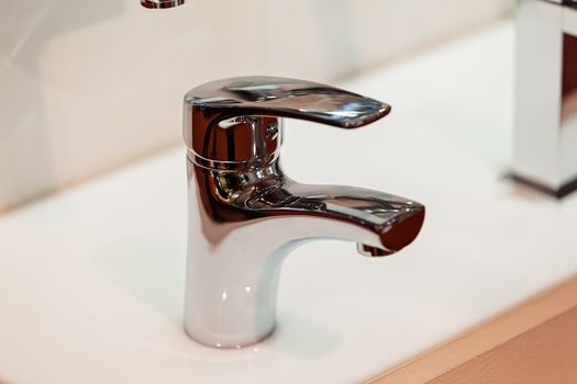 Modern faucet for water on the sink or on the wall, note shallow depth of field