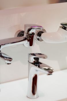 Modern faucet for water on the sink or on the wall, note shallow depth of field