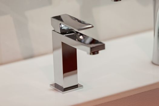 Modern faucet for water on the sink or on the wall, note shallow depth of field