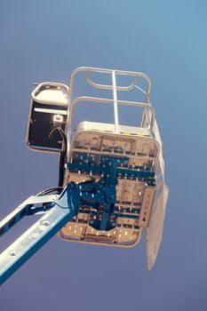 Crane with basket on the blue background, note shallow depth of field