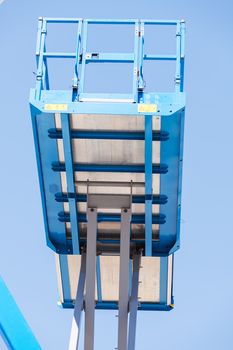 Crane with basket on the blue background, note shallow depth of field