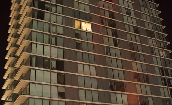 Single light on in modern apartment block