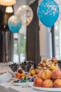 Festive buffet at event with desert, fruits and balloons