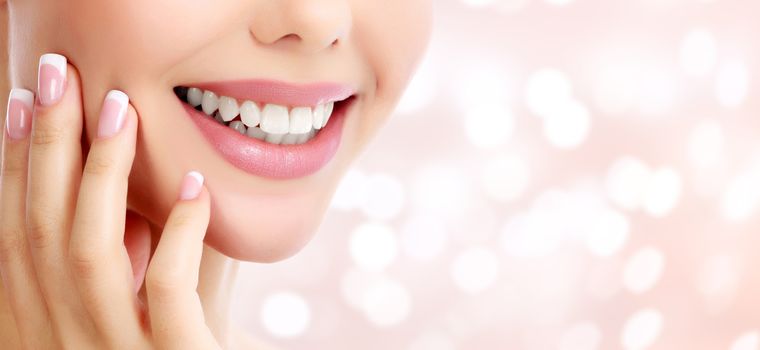 Closeup shot of beautiful female smile, abstract background with blurred lights