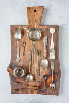 Various tableware on a wooden cutting board. Vertical image